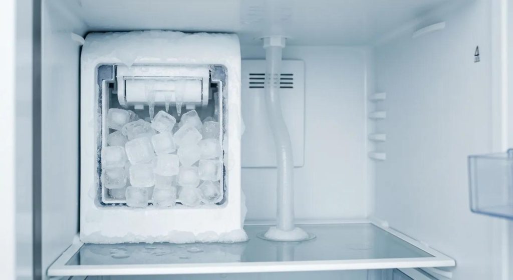Ice maker inside a refrigerator with stuck ice cubes and a frozen fill tube, showcasing common problems