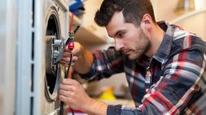 washing-machine-repair-technician Technician repairing washing machine motor during appliance repair service