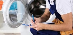Technician inspecting and diagnosing a front-load washing machine during a washing machine repair in Charlotte